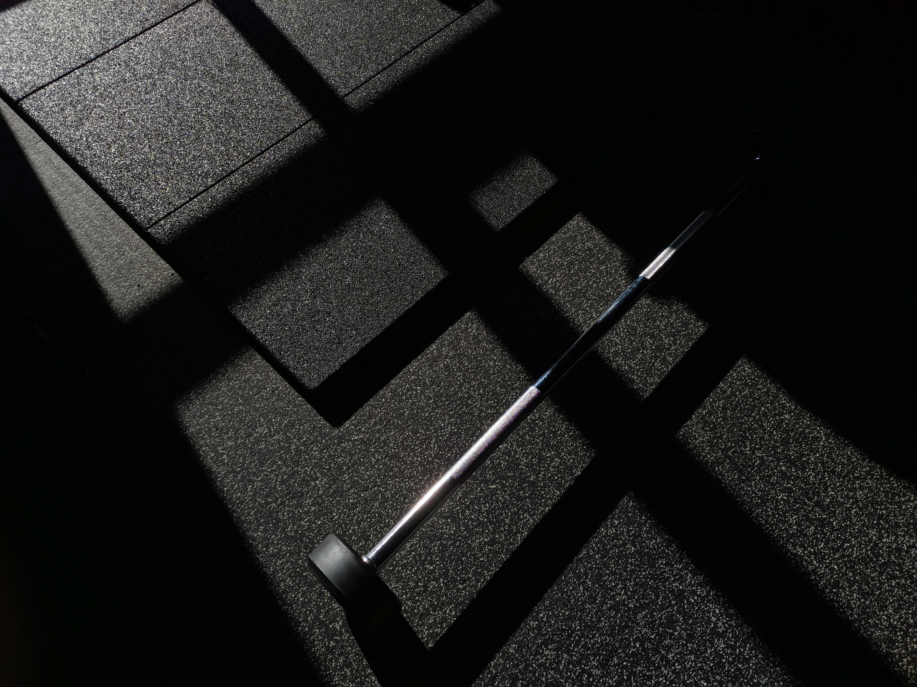 Barbell resting in a dark gym